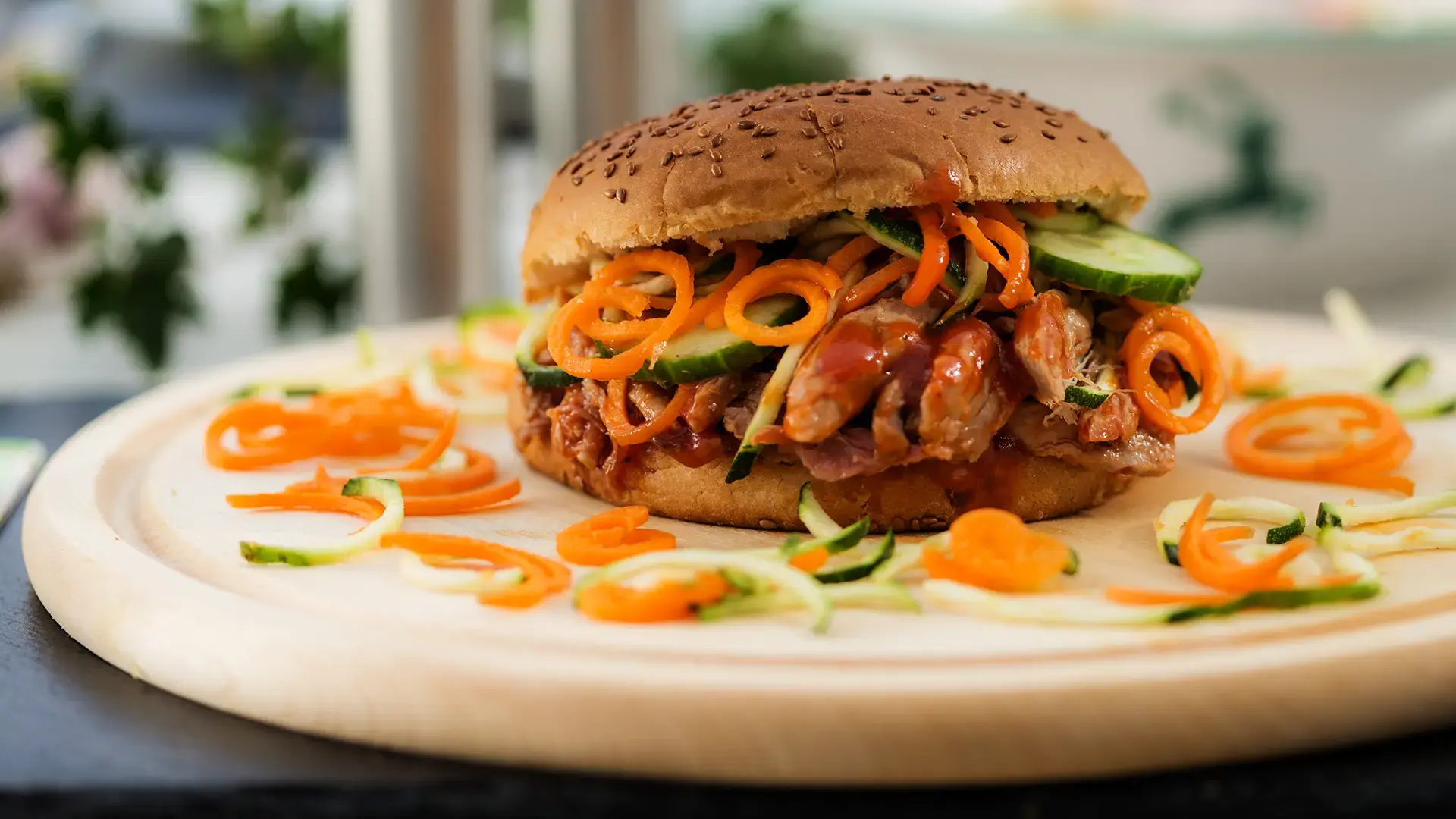 Rottaler Burger mit gezupftem Schweinenacken im Roggenbun, serviert auf Holzscheibe und Schiefer mit Grillgemüse im Brotlaib