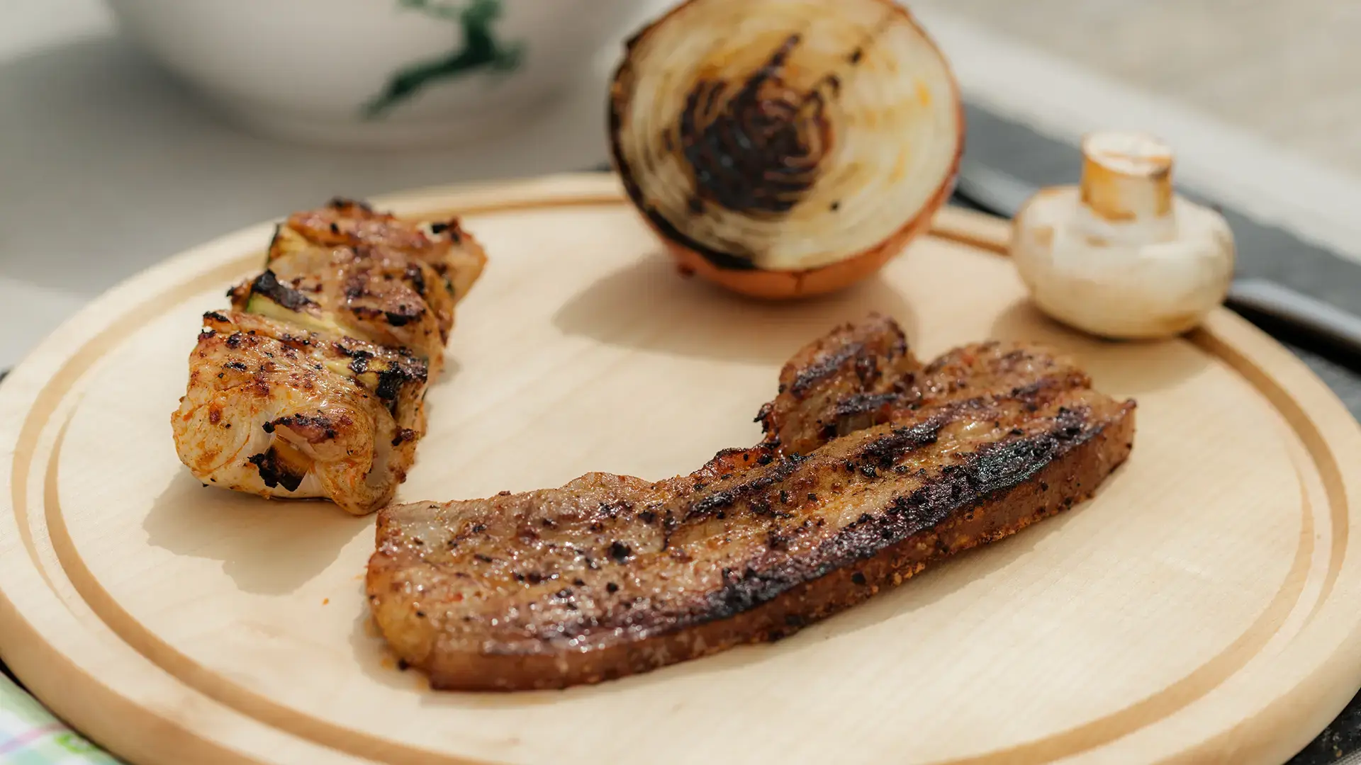 Knuspriger Schweinebauch (Wammerl) von der Rottaler Strohsau, serviert mit Grillgemüse auf einer echten Holzscheibe