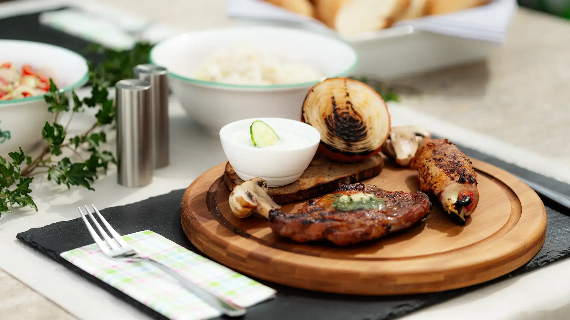 Angus Steak vom Grill mit Scampispieß, serviert mit Salatvariationen in Gmundner Keramik und gemischtem Brotkorb