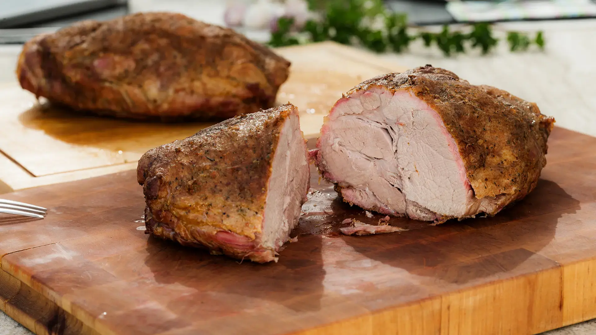 Rottaler Schweinenacken aus dem Smoker auf einem Eichenbrett der Schreinerei Renaltner mit Folienkartoffel